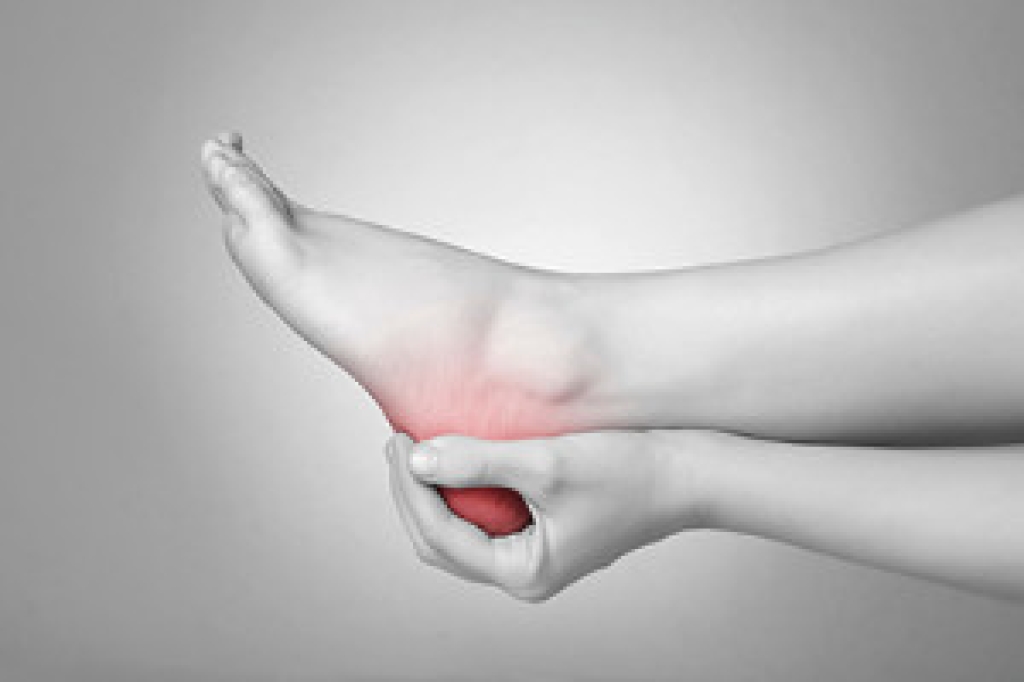 Person gripping the back of the heel in pain